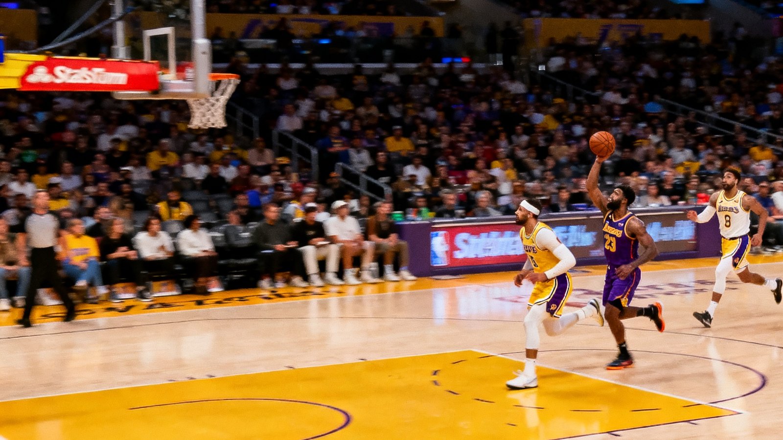 NBA常规赛高清直播画面：洛杉矶湖人主场斯台普斯中心，球员正在快攻上篮，比分108比102，第四节剩余2分30秒，观众席座无虚席